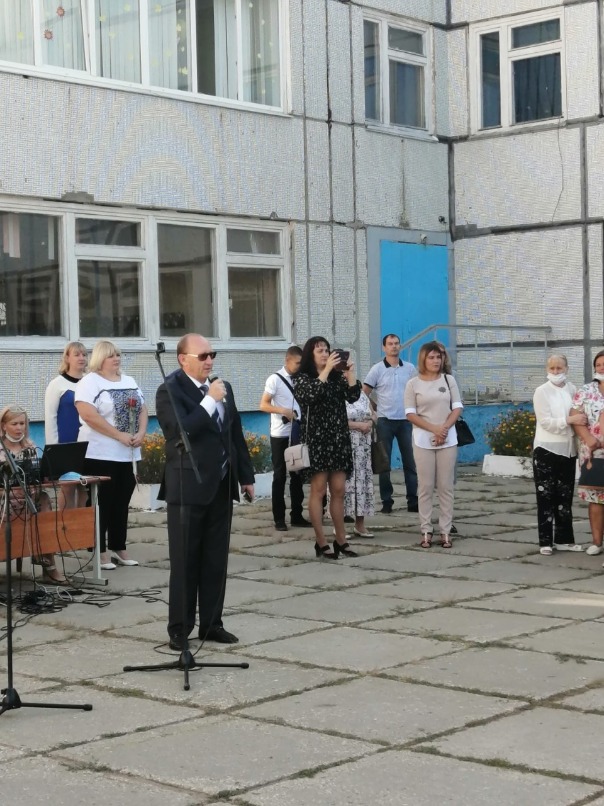 На переднем плане - депутат Андрей Иванов, выступающий на линейке в честь Дня знаний.